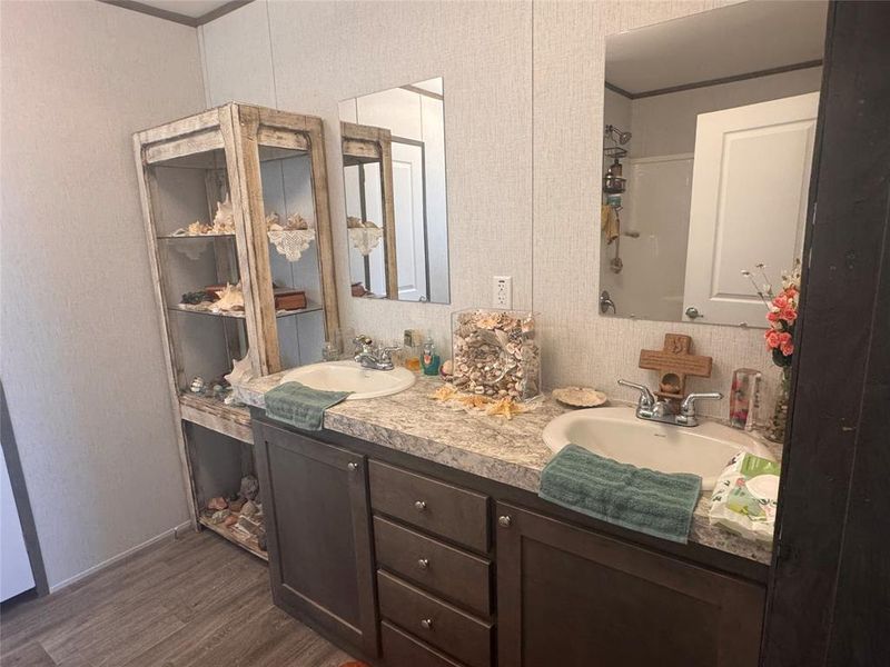 Full bathroom featuring double vanity and dark wood-style floors Full bathroom featuring double vanity and dark wood-style floors