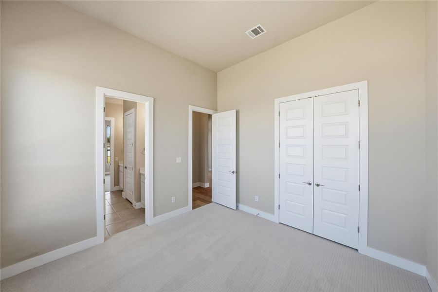 Unfurnished bedroom with carpet, a closet, and ensuite bath