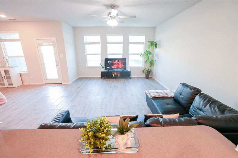 Living room with ceiling fan and hardwood / wood-style floors