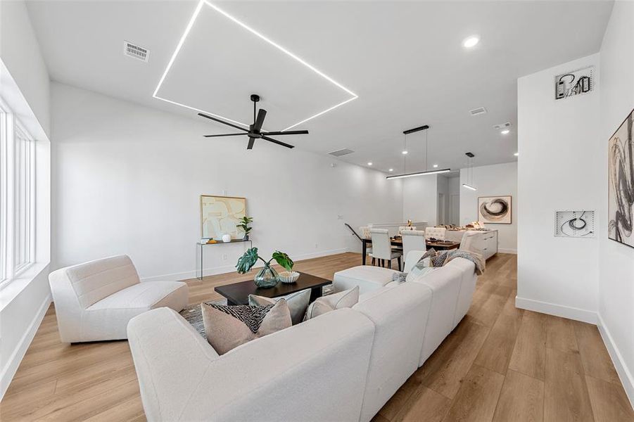 Living area with light wood-style floors, ceiling fan, and recessed lighting Living area with light wood-style floors, ceiling fan, and recessed lighting
