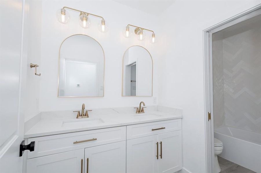 Full bath with double vanity and shower / bath combination