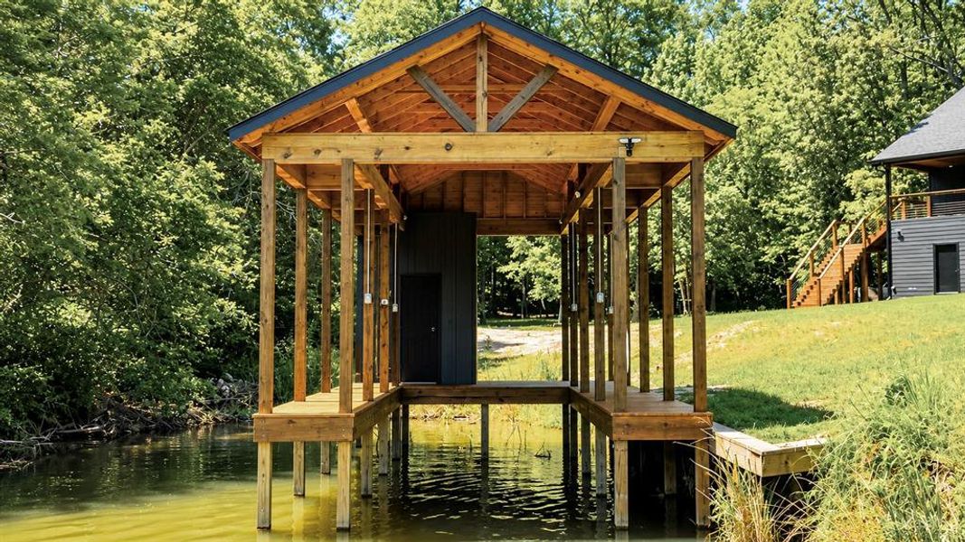Wood-frame boat dock with a gabled roof, featuring a private storage shed, multiple covered slips, and integrated lighting fixtures