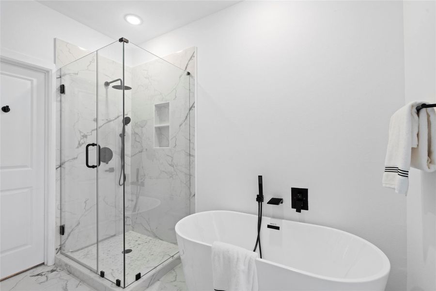 The primary bath blends luxury and practicality with a frameless glass shower and a freestanding soaking tub set against marble-look tile—spa-like design that stays within reach. The primary bath blends luxury and practicality with a frameless glass shower and a freestanding soaking tub set against marble-look tile—spa-like design that stays within reach.