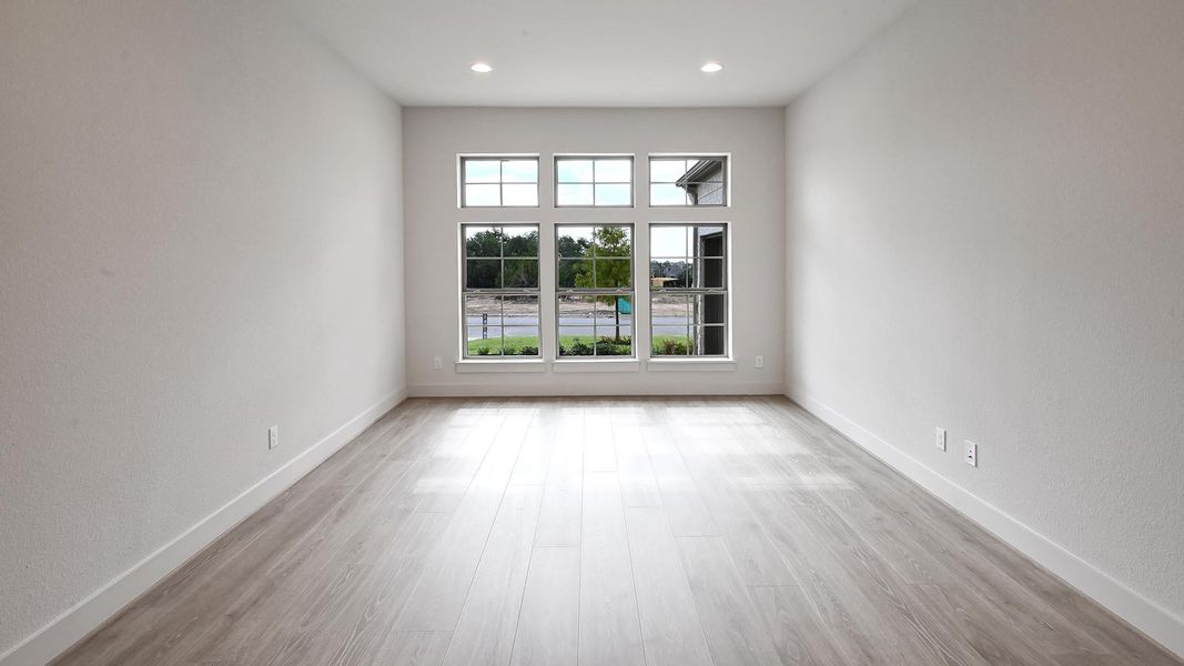 Unfurnished room with light wood-style floors, a textured wall, and recessed lighting