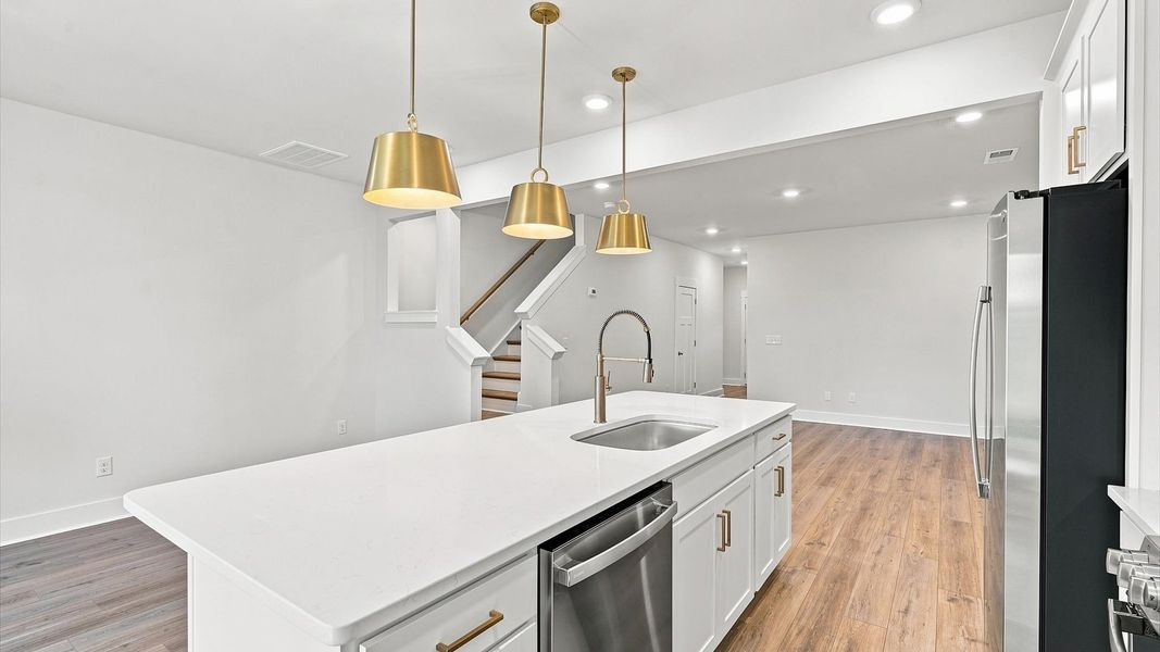 Exceptional culinary space with a striking 9-foot island and eye-catching pendant lights by DRB Homes Exceptional culinary space with a striking 9-foot island and eye-catching pendant lights by DRB Homes