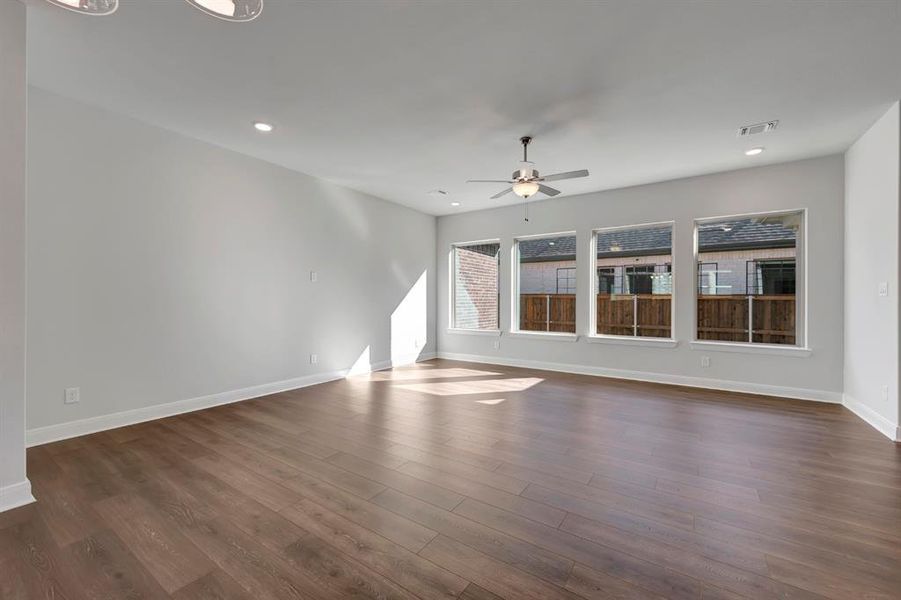 Unfurnished living room with a ceiling fan, recessed lighting, and dark wood-type flooring