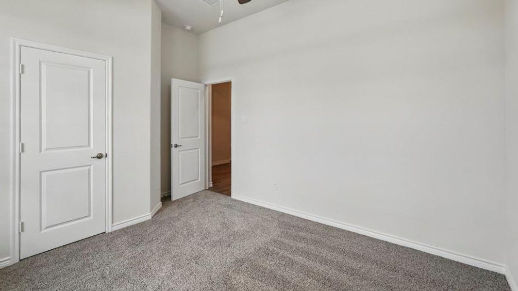 Neutral tone wall finishes paired with gray carpet flooring and white trim