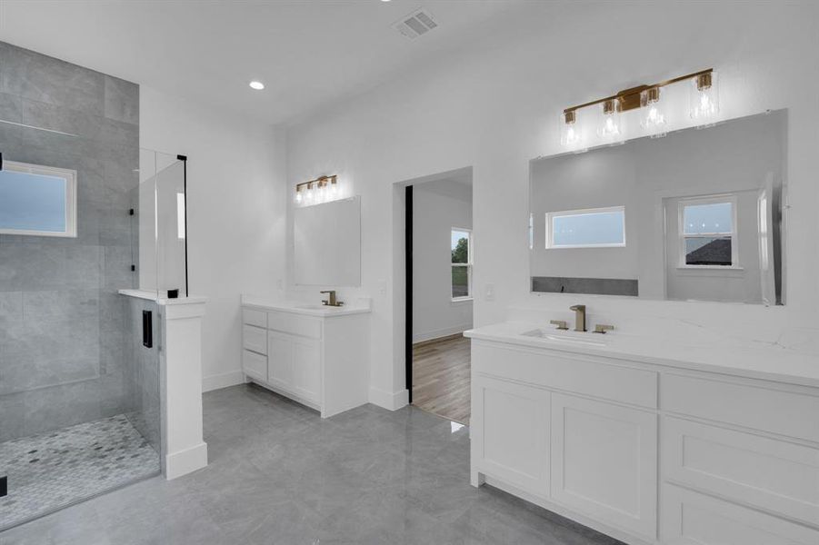 Bathroom featuring double vanity, tiled shower, and hardwood / wood-style flooring