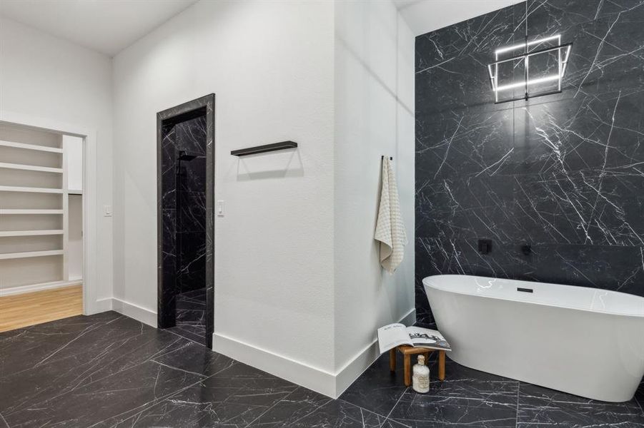 Bathroom featuring tile walls, built in features, and plus walk in shower