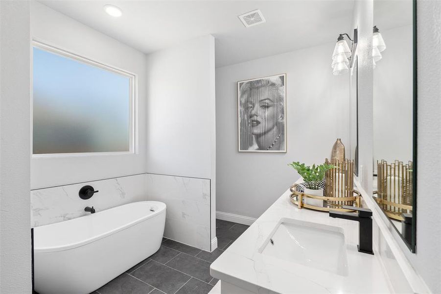 Bathroom featuring vanity, a bath, and tile patterned flooring