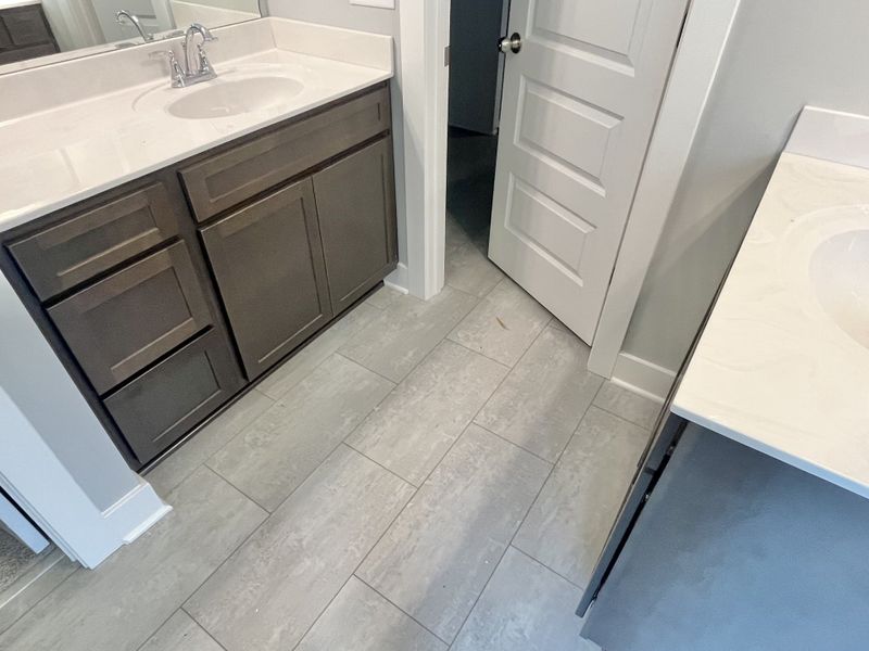 Separate couple's vanities and luxury vinyl tile.