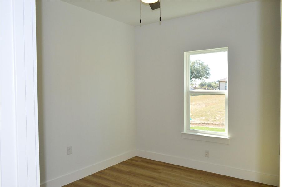 Spare room featuring wood finished floors and ceiling fan Spare room featuring wood finished floors and ceiling fan