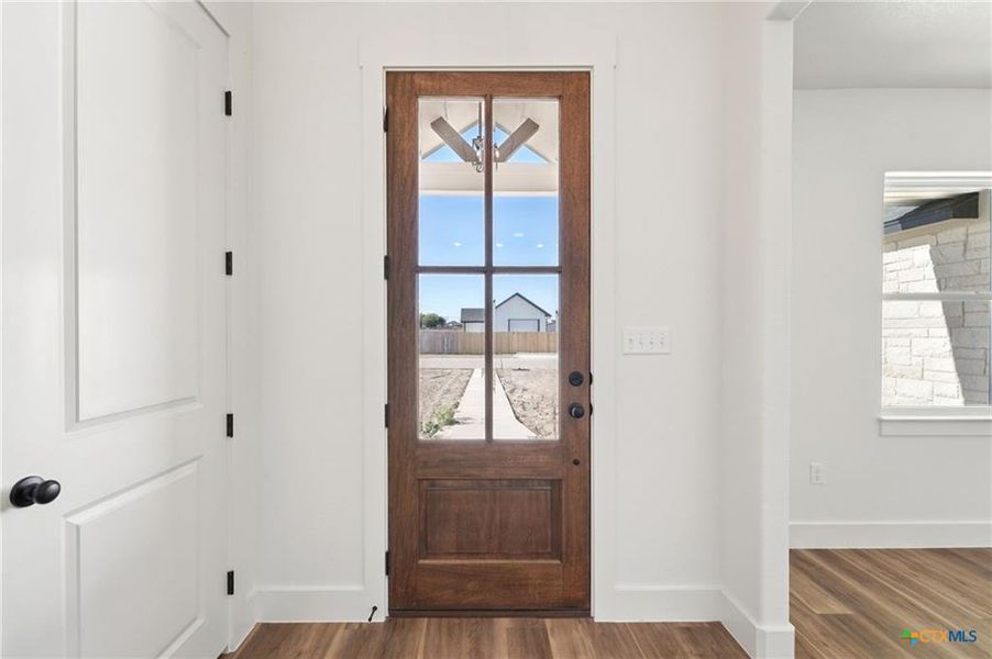 A welcoming wooden front door with clear glass panels invites light into the interior. A welcoming wooden front door with clear glass panels invites light into the interior.