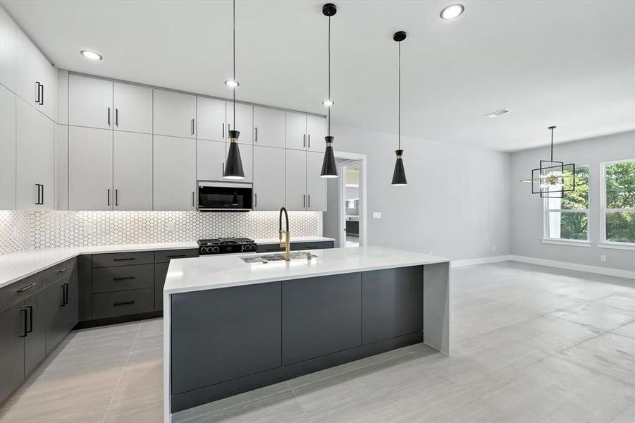 Kitchen featuring a kitchen island with sink, gray cabinets, light stone countertops, tasteful backsplash, and recessed lighting Kitchen featuring a kitchen island with sink, gray cabinets, light stone countertops, tasteful backsplash, and recessed lighting