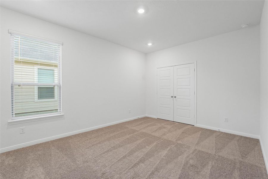 Across the hallway, this spacious secondary bedroom offers a comfortable retreat for family or guests.