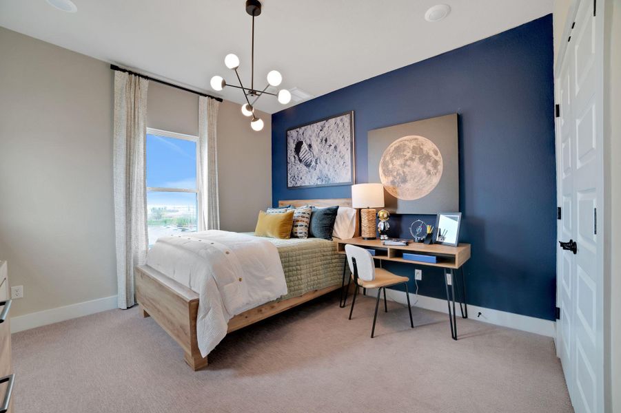 Bedroom with light colored carpet and a chandelier