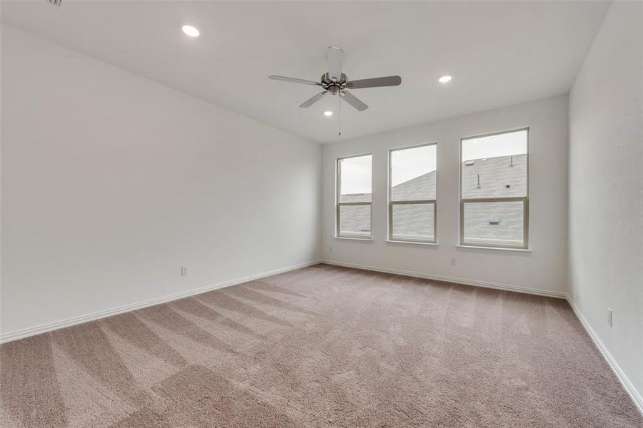 Spare room featuring light carpet and ceiling fan