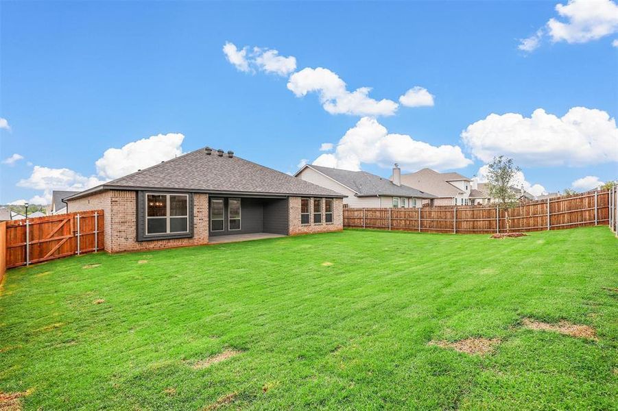 Back of property with a patio and a lawn