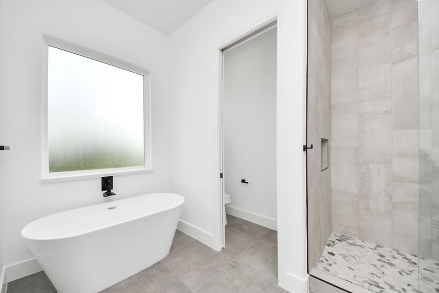 Primary bathroom w/ large soak in tub, frosted window for natural light. Primary bathroom w/ large soak in tub, frosted window for natural light.