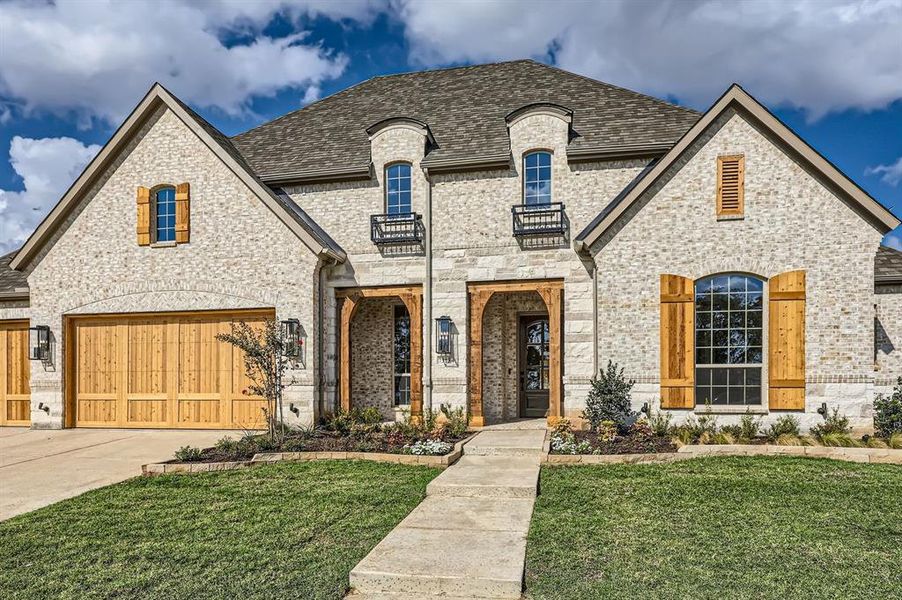 French country home with a front yard and a garage