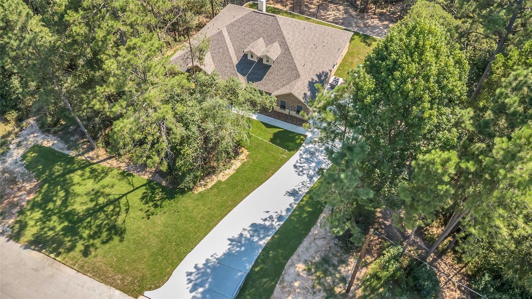 This aerial view showcases a charming home nestled among mature trees. It features a long driveway, a well-maintained lawn, and is surrounded by lush greenery, offering a sense of privacy and tranquility. This aerial view showcases a charming home nestled among mature trees. It features a long driveway, a well-maintained lawn, and is surrounded by lush greenery, offering a sense of privacy and tranquility.