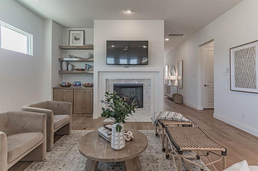 Living room featuring a brick fireplace and light wood-type flooring