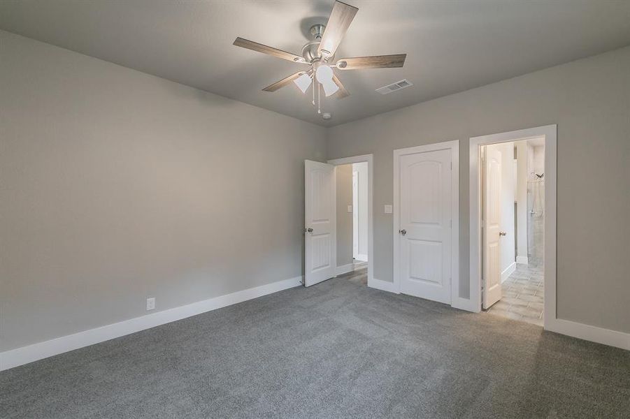 Primary bedroom featuring carpet flooring and ceiling fan