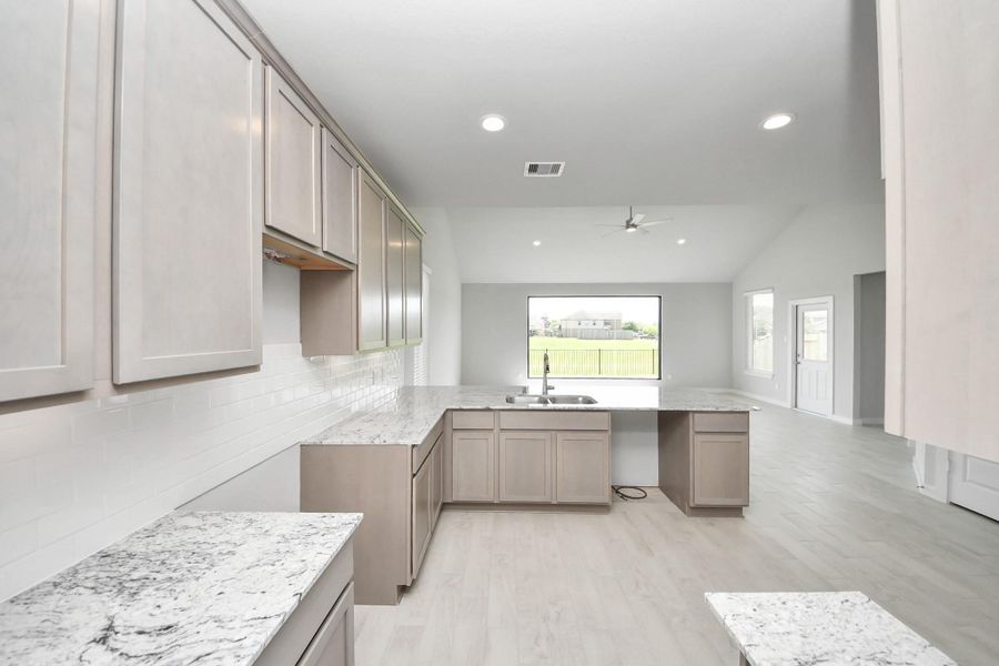 The kitchen is a culinary haven, featuring granite countertops, a tile backsplash, stainless steel appliances, and 42” upper cabinets. The kitchen is a culinary haven, featuring granite countertops, a tile backsplash, stainless steel appliances, and 42” upper cabinets.