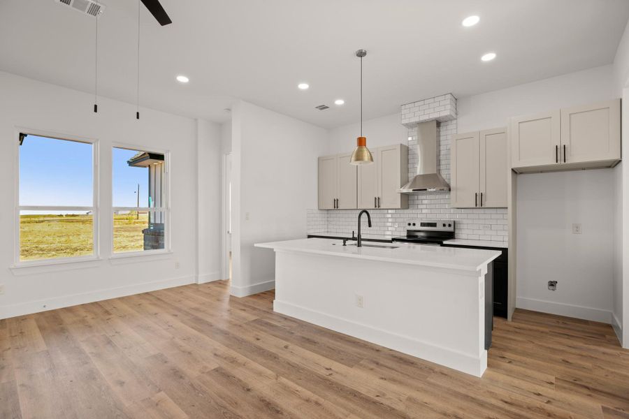 A contemporary kitchen and living area featuring sleek cabinetry, modern appliances, and generous natural light. A contemporary kitchen and living area featuring sleek cabinetry, modern appliances, and generous natural light.