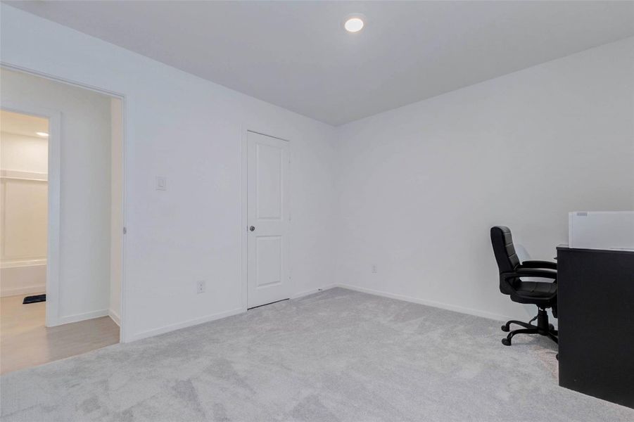 Additional spacious bedroom with soft carpeting, natural light, and convenient access to the full hall bathroom.