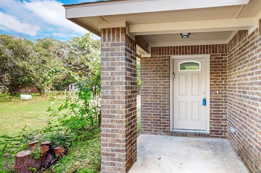 View of exterior entry featuring a lawn