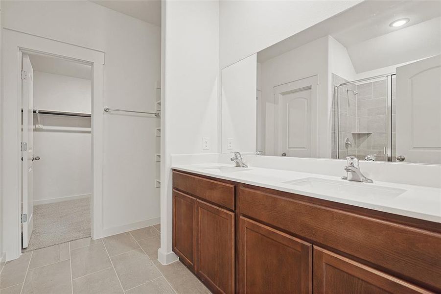 Bathroom featuring vanity, tile patterned floors, and an enclosed shower