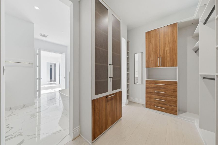 The custom closet features dedicated hanging space, rich wood-grain drawers and closed cabinetry. The custom closet features dedicated hanging space, rich wood-grain drawers and closed cabinetry.