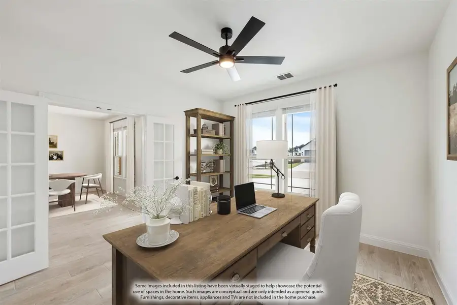 Home office with wood desk, ceiling fan, and French doors opening to dining area