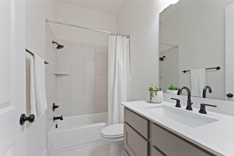 Contemporary bathroom featuring a single vanity with a white countertop and dark gray cabinetry