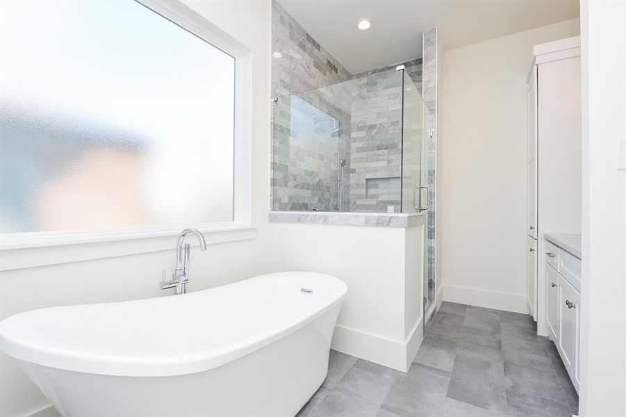 Primary bathroom with honed Carrera marble countertops and separate sinks.