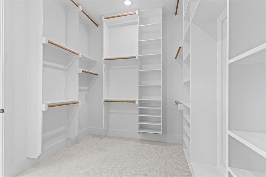 Walk in closet with light colored carpet