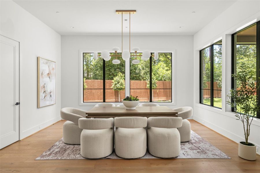 The dining area features large windows, and a beautiful light fixture.
