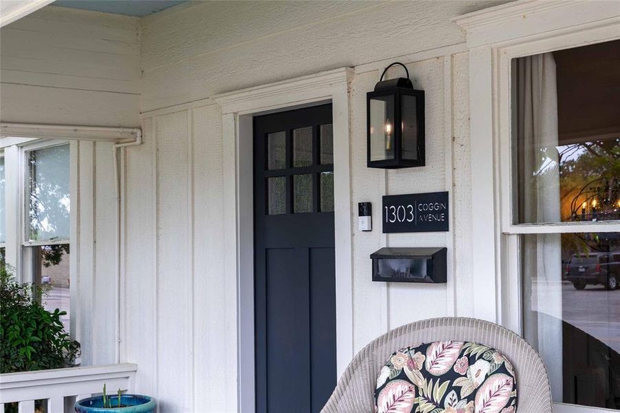 White board and batten exterior featuring a dark paneled entry door with glass inserts