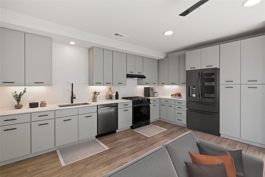 Kitchen featuring fridge with ice dispenser, stainless steel dishwasher, a sink, black gas range, and under cabinet range hood