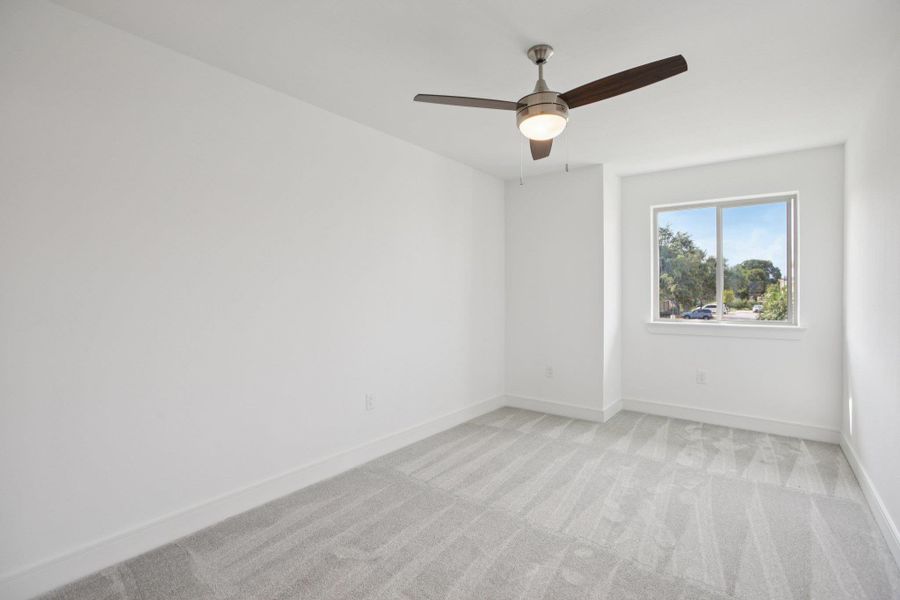 Spare room with light colored carpet and ceiling fan