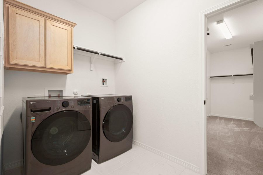 The main floor laundry room also conveniently connects to the oversized primary walk-in closet. Featuring both gas & electric dryer hookups. The main floor laundry room also conveniently connects to the oversized primary walk-in closet. Featuring both gas & electric dryer hookups.