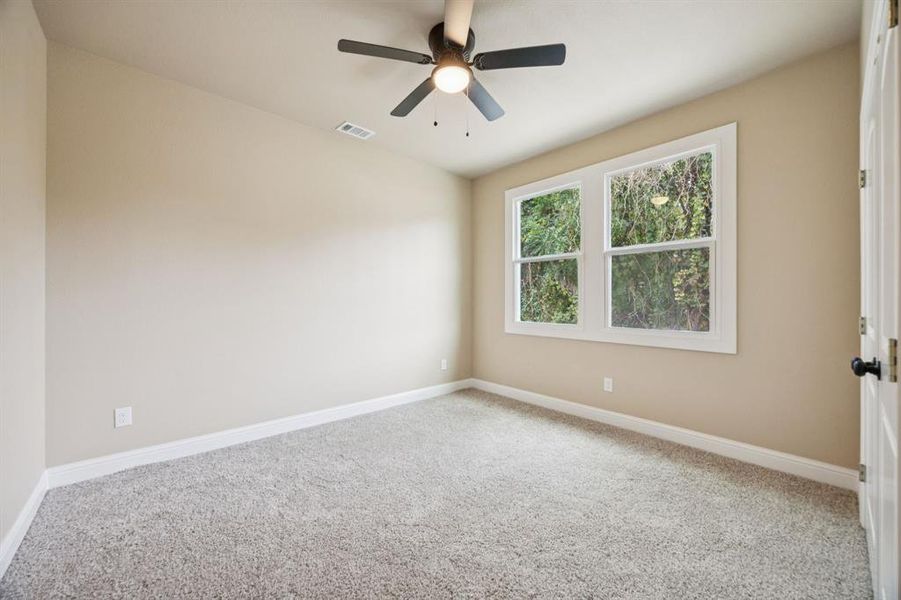 Carpeted spare room with baseboards and a ceiling fan Carpeted spare room with baseboards and a ceiling fan
