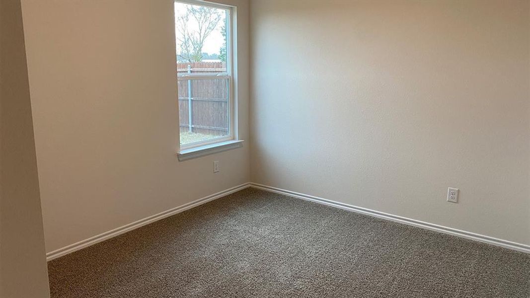 Spare room with dark colored carpet and baseboards