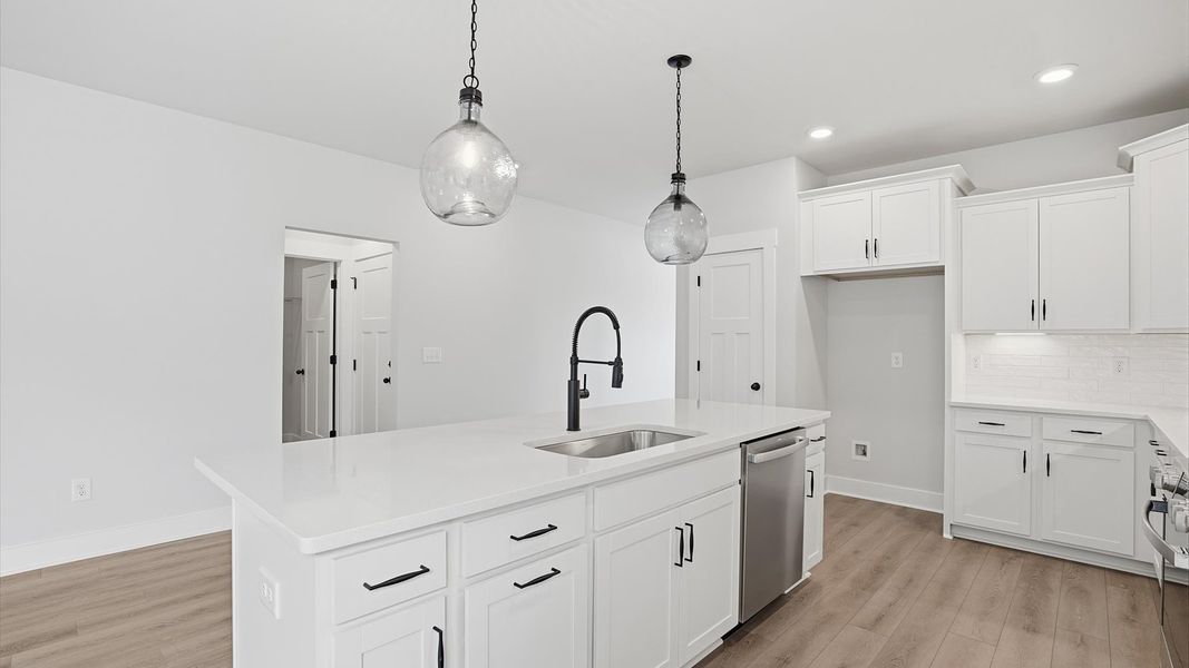 Notable kitchen space with elegant pendant lighting and a large island perfect for entertaining at Creeks at Midway