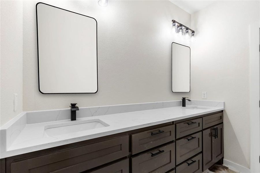 Dual vanity featuring quartz countertops, undermount sinks, and matte black fixtures