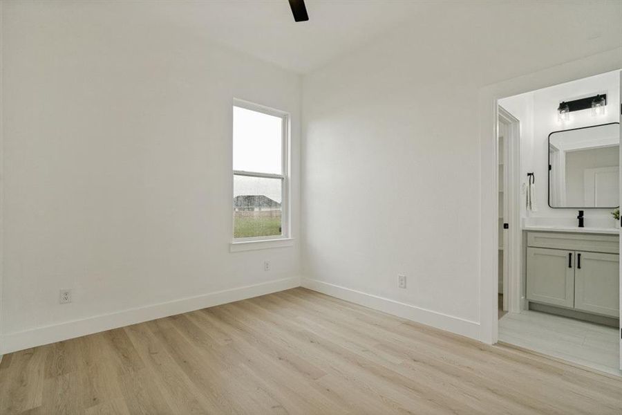 Bedroom featuring light wood-finish flooring and a single window Bedroom featuring light wood-finish flooring and a single window