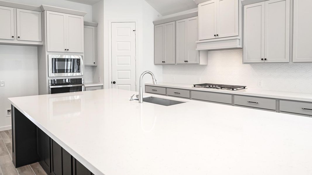 Kitchen featuring decorative backsplash, stainless steel appliances, light stone countertops, and light wood-style flooring Kitchen featuring decorative backsplash, stainless steel appliances, light stone countertops, and light wood-style flooring