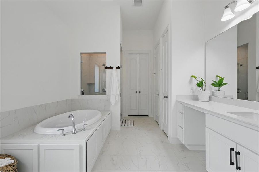 Full bathroom featuring a garden tub, visible vents, shower, two vanities, and marble finish floor