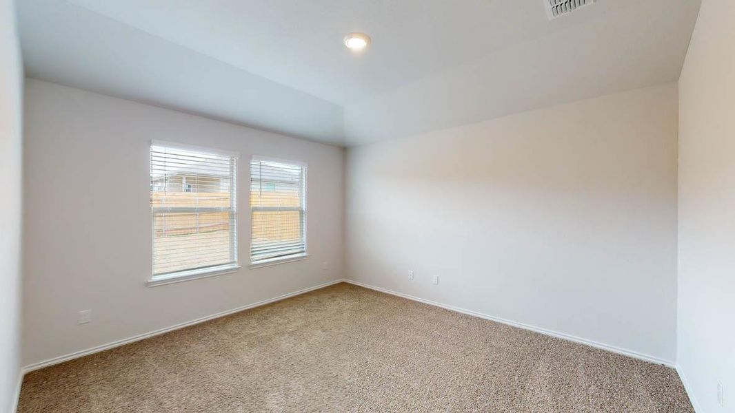 Carpeted room featuring two windows with blinds, a white ceiling with a recessed light, and white baseboards